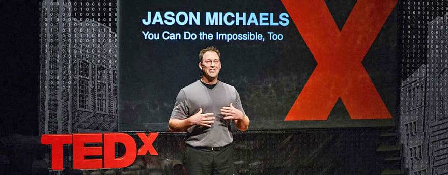 Jason Michaels speaking while on stage at a TedX conference